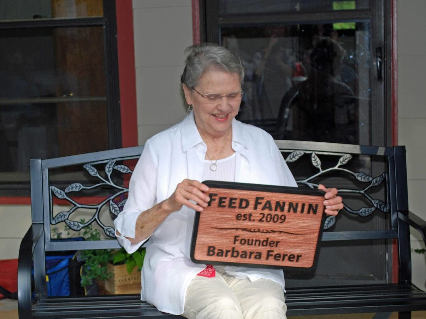 Feed Fannin founder Barbara Ferer smiling, holding a plaque with her name on it.